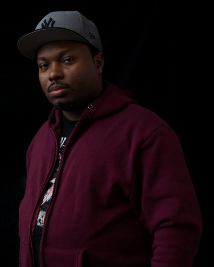 DJ Epidemik in a maroon hoodie and grey cap